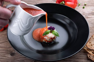 Siyah bir tabakta karides ile Gazpacho soğuk çorba