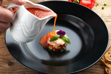 Siyah bir tabakta karides ile Gazpacho soğuk çorba