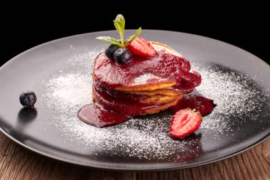 Siyah bir tabak üzerinde çilek reçeli ile Börek