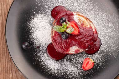 Siyah bir tabak üzerinde çilek reçeli ile Börek