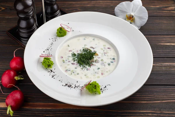 Okroshka en un plato blanco sobre una mesa de madera —  Fotos de Stock