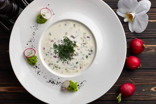 Okroshka en un plato blanco sobre una mesa de madera —  Fotos de Stock