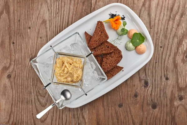 Caviar of pike on a white plate with toasts and ice — Stock Photo, Image