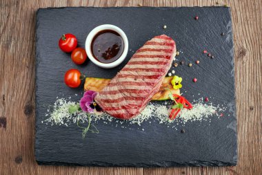 Siyah bir taş üzerinde soslu et bifteği