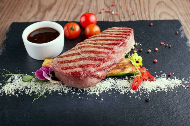 Siyah bir taş üzerinde soslu et bifteği