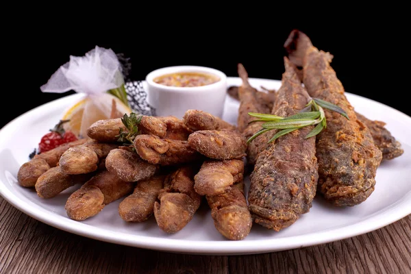 Pescado frito en un plato blanco, en una tabla. Toros, Barabola —  Fotos de Stock