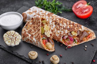 Et soslu, soğanlı, turşulu, domatesli, sarımsaklı, otlu ve mantarlı Shawarma.