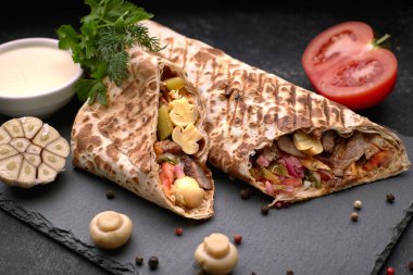 Et soslu, soğanlı, turşulu, domatesli, sarımsaklı, otlu ve mantarlı Shawarma.