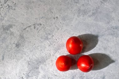 Hafif arka planda üç taze domates.