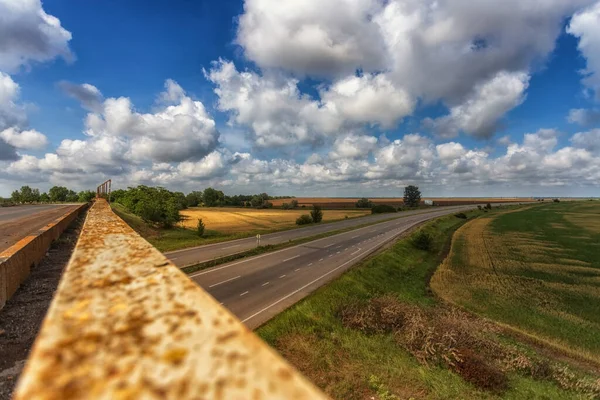 Autostrada Wysokości Mostu Zardzewiałym Ogrodzeniem Tle Chmur Pól Błękitnego Nieba — Zdjęcie stockowe