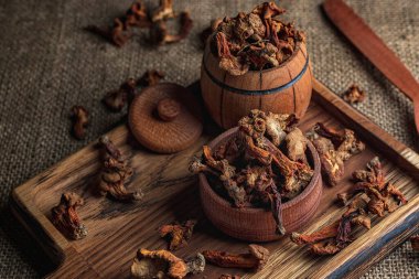 Kurutulmuş chanterelle mantarı, Cantharllus cibrius, ahşap bir tahtanın üzerinde, kabataslak bir arka planda, çuval bezi.