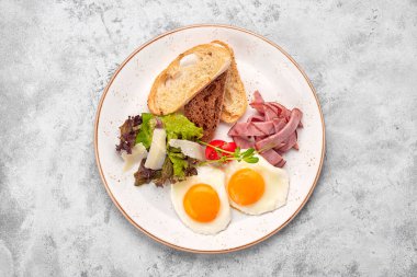 Kızarmış yumurta, domatesli, jambonlu ve ciabatta tostlu, beyaz arka planda. Kahvaltı.