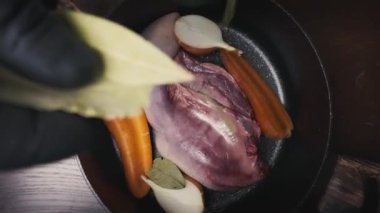 Profesyonel şef mutfakta pişmiş sığır dili pişirip doğruyor. Geleneksel et hazırlama süreci videoya kaydedildi