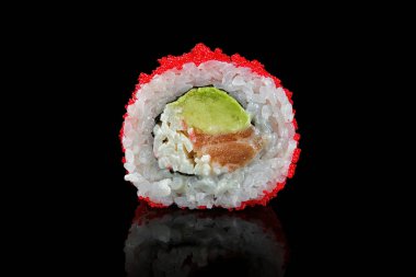 Somon, avokado, yengeç çubukları ve tobiko içeren parlak siyah bir arka plana yerleştirilmiş suşi rulosunun yakın çekimi.