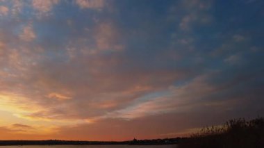 Donmuş bir gölün üzerinde canlı kış günbatımı dramatik bir gökyüzü ve parlayan renkler