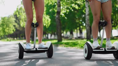 Seksi kızlar kısacası Segways kapatmak - yavaş beyaz kot şort binmek