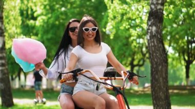 Tatlı sexy girls kısa şort binmek bir elektrikli scooter parkta pamuk.
