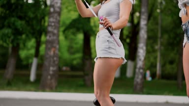 İki güzel genç kızlar seksi kıyafetler içinde gülüyor ve ağır çekimde sabun köpüğü ile oynarken hafta sonu bir Segway parkta sürme sırasında dans