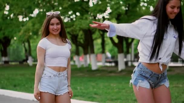 Deux jeunes filles sexy chevauchant sur Segway en short tenant la main et riant lors d'une journée ensoleillée dans le parc — Video