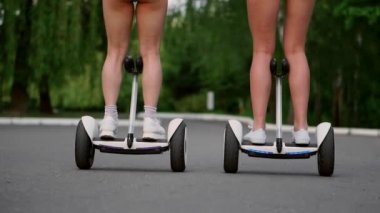 Gyroscooter bir güneşli yaz gününde binme kısa şortlu kız sırt legs yakından görmek