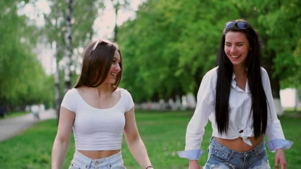 Δύο όμορφα κορίτσια το γέλιο βόλτα στο πάρκο με Gyroscooter σε μια ηλιόλουστη καλοκαιρινή μέρα — Αρχείο Βίντεο
