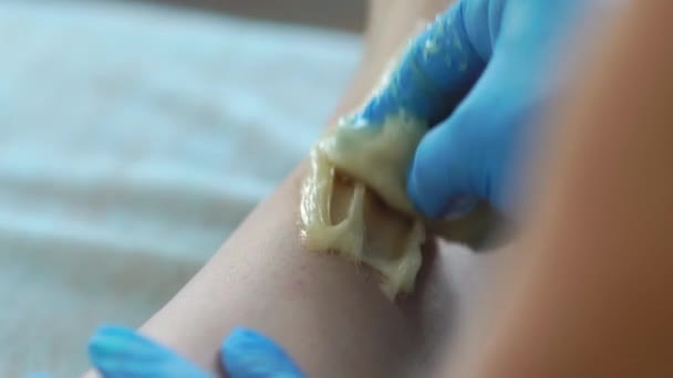 Närbild av befälhavaren på hårborttagning hand ta bort små hårstrån med en speciell teknik för sötning att göra kraftiga ryck med handen — Stockvideo