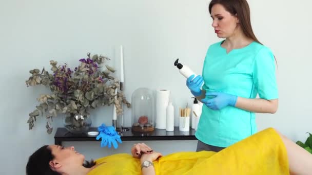 The girl is a master of hair removal with the help of shugaring advises the client to the girl about the possibilities of the procedure — Stock Video