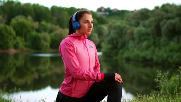 A menina aquece no início da manhã antes de treinar se preparando para uma corrida ao sol — Vídeo de Stock