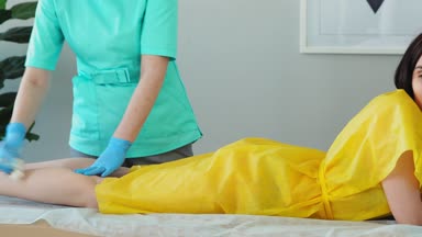 Kız görüşmeler telefon ve bacaklarının üzerinde epilasyon sırasında gülümsüyor. Shugaring ana saç legs--dan kaldırır.