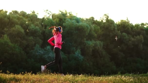 Ráno jog v parku u rybníka v sluneční paprsky úsvitu, dívka se připravuje na Mariano a vést zdravý životní styl — Stock video