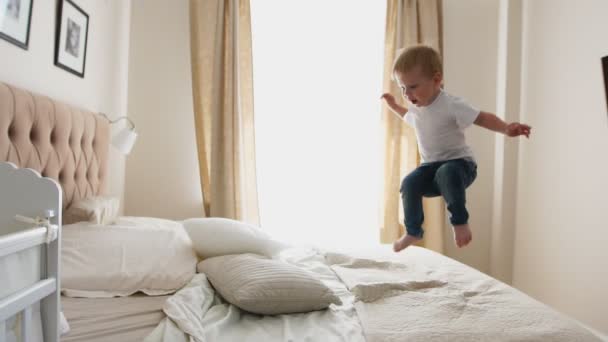 石鹸の泡の飛行を見てベッドの上の幸福から飛び降り — ストック動画