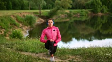 Pembe bir ceket, bir kız için bir çalışma sıcak kadar hazırlanıyor ve kulaklık telefon aracılığıyla müzik dinle