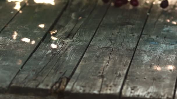 Bayas rojas de cerezas maduras caen sobre una mesa de madera en cámara lenta — Vídeos de Stock