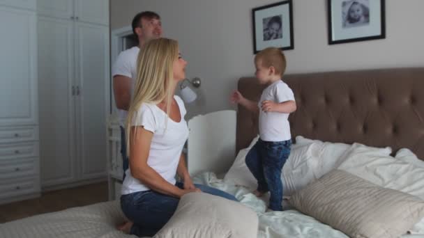 Familia feliz jugando a las almohadas lucha en la cama en casa — Vídeos de Stock