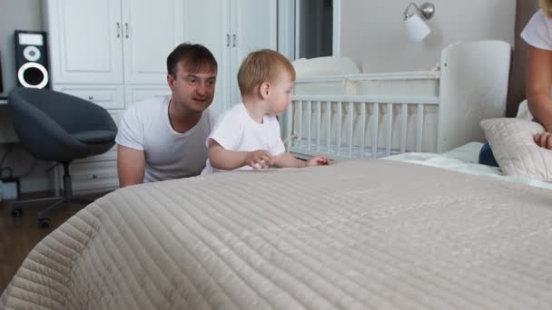 家庭在家里度过空闲时间 欢快的家庭与他们的女儿在床上的乐趣 — 图库视频影像