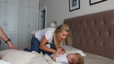 Anne ve baba çocuğunu gıdıklıyor. insanlar, Aile, eğlence ve sabah kavramı - evde yatakta gıdıklama ailesi ile mutlu bir çocuk. Mutlu aile birlikte oynama ve sarılma yatmadan zaman harcama