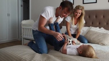 Anne ve baba çocuğunu gıdıklıyor. insanlar, Aile, eğlence ve sabah kavramı - evde yatakta gıdıklama ailesi ile mutlu bir çocuk. Mutlu aile birlikte oynama ve sarılma yatmadan zaman harcama
