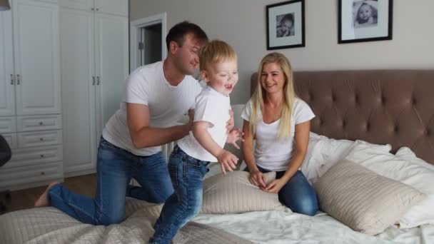 Eltern amüsieren sich mit ihrer kleinen Tochter im Bett. Familie verbringt Zeit am Morgen — Stockvideo