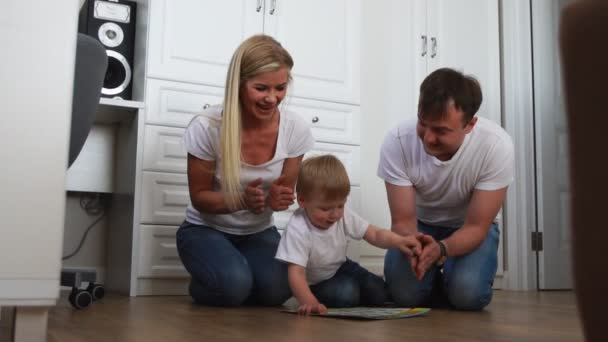 Papai e mamãe sentados no chão aplaudiram a criança que completou com sucesso a tarefa — Vídeo de Stock