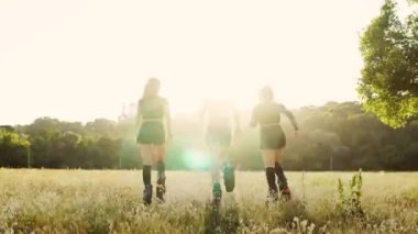 Yaz parkta spor yaparken günbatımında çalışan yaylar ile Çizmeli üç kız