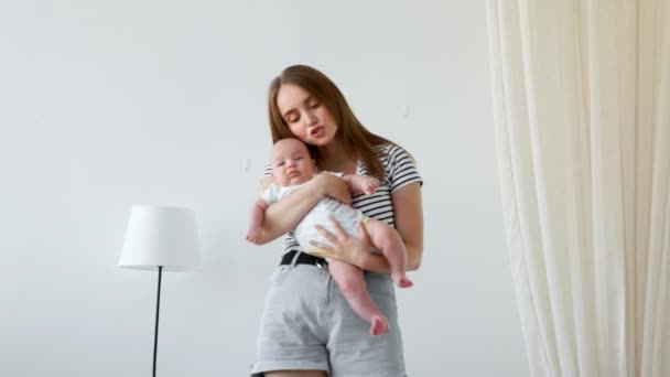 Feliz familia amorosa. Madre jugando con su bebé en el dormitorio — Vídeos de Stock