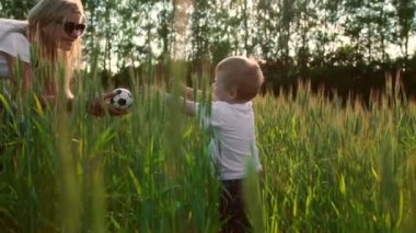 Sevgi dolu bir anne ve oğlu alanında iletişim kurmak ve sarılmak için güneş ışınlarının saç aydınlatmak. Mutlu bir aile