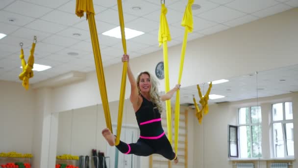 La chica en las clases de yoga de Aero está en la cuerda sentada en una hamaca en el aire — Vídeos de Stock