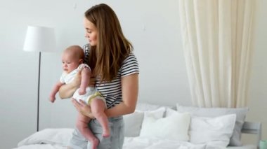 Beyaz bir daire içinde modern bir genç Aile kavramı. Anne bebek ona ninni şarkı yatağa koyar.