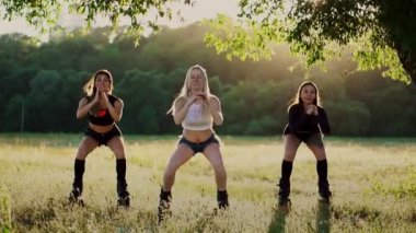 Grup Eğitim kangoo. Gün batımında üç kız dinamik egzersiz kilo kaybı ve kas güçlendirme amaçlı gerçekleştirmek