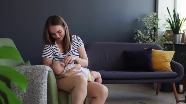 Годування грудьми. мати годує дитину в темряві в ліжку — стокове відео