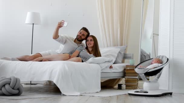 Nahaufnahme Porträt eines glücklichen Paares, das ein Selfie mit Baby macht — Stockvideo