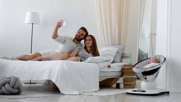 De cerca retrato de una feliz pareja tomando una selfie con el bebé — Vídeos de Stock