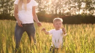 Mutlu bir aile kavramı. Çavdar alanında, çocuk ve annesi birbirlerine arka ışık spikelets içinde gülümseyen sever misiniz
