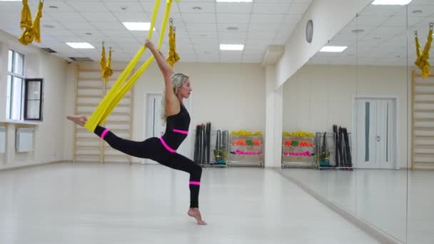 Sport healthy lifestyle concept. Copy space. Fit pretty young woman wearing sportwear doing fly yoga stretching exercises in fitness training white gym loft classroom. — Stock Video
